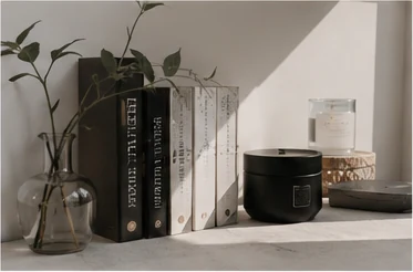 Minimal still life with design books, candle and glass vase