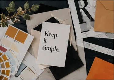 Brand identity materials, colour references and editorial papers arranged on a desk