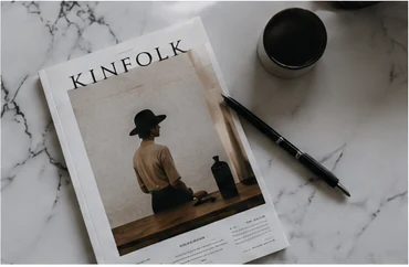 Independent design magazine and black coffee on a marble desk