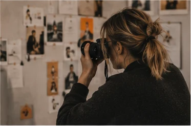 Photographer documenting a moodboard in a warm creative studio